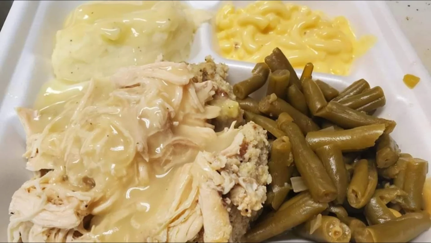 Poultry, dressing and gravy with mashed potatoes, macaroni and green beans