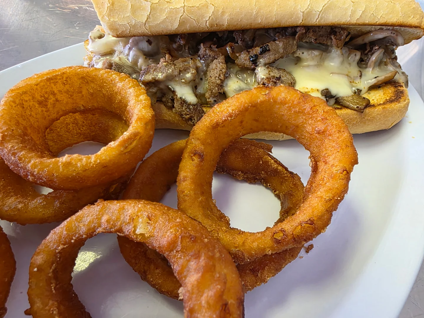 Philly steak sandwich and onion rings