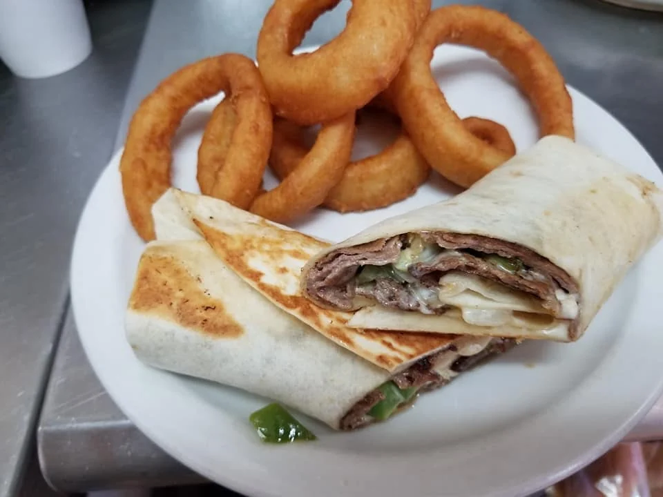 Steak wrap halves with melted cheese and onion rings